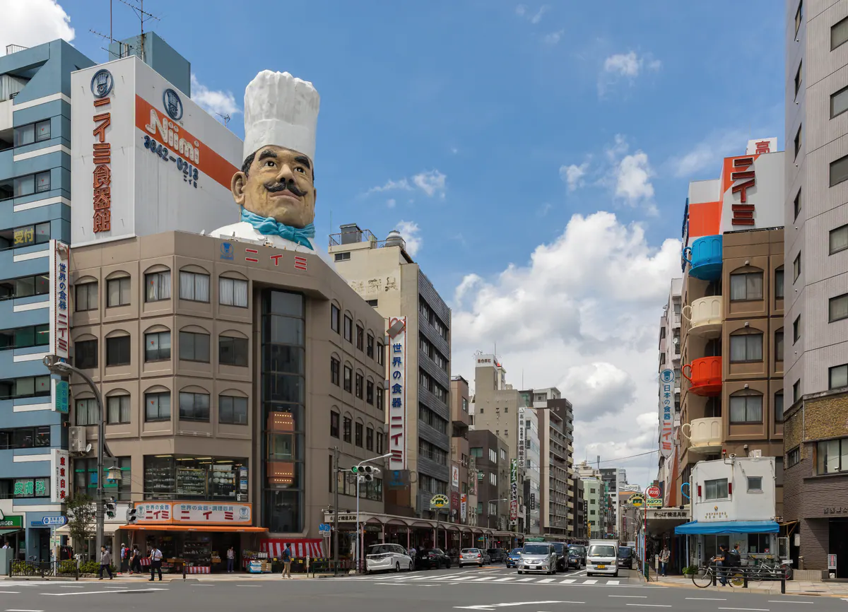 The large chef figure above a kitchenware building at a Kappabashi street intersection