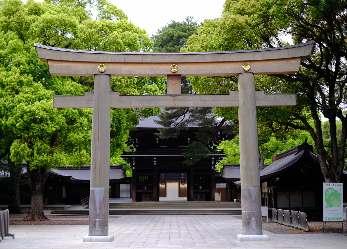 A stone torii gate and leafy approach at Meiji Jingu in Tokyo